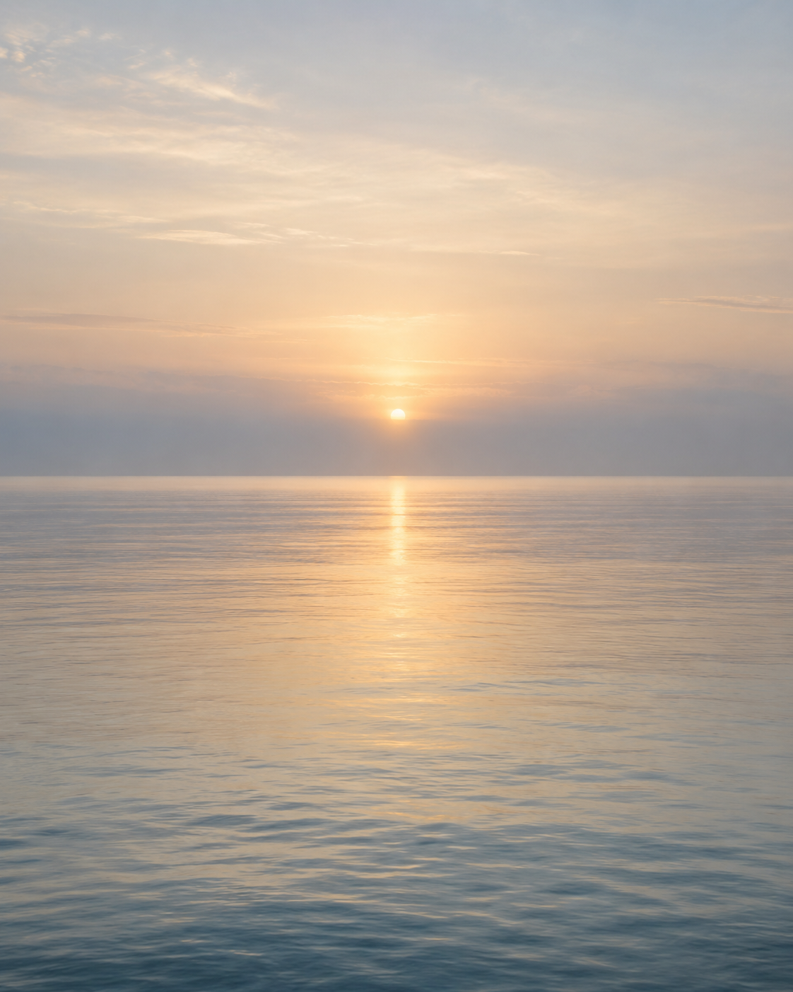 A pale sunrise over calm sea water